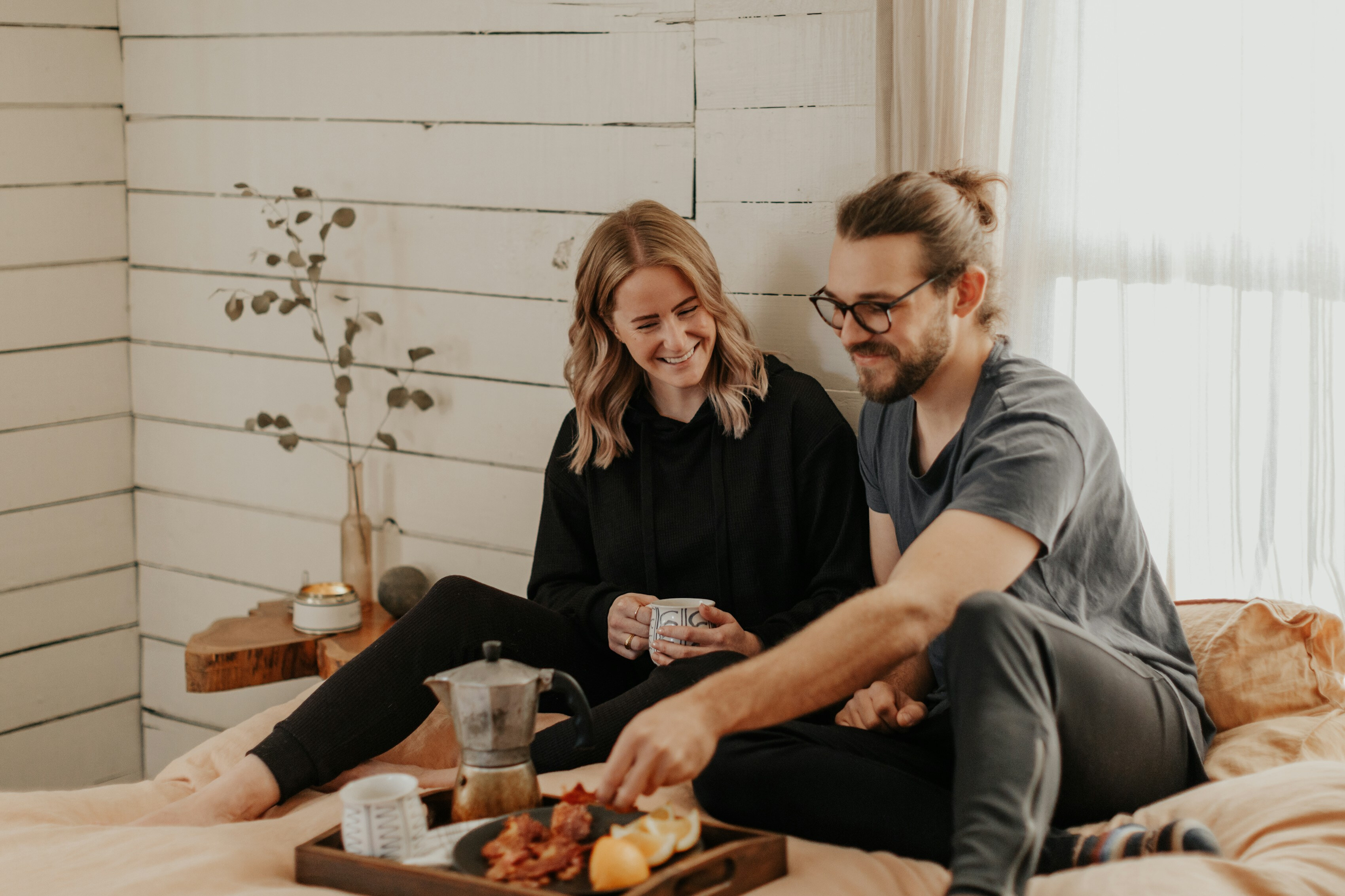 A couple laughing together over breakfast at home